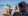A man takes a photo of a performer with a guest on the beach at a pop-up event