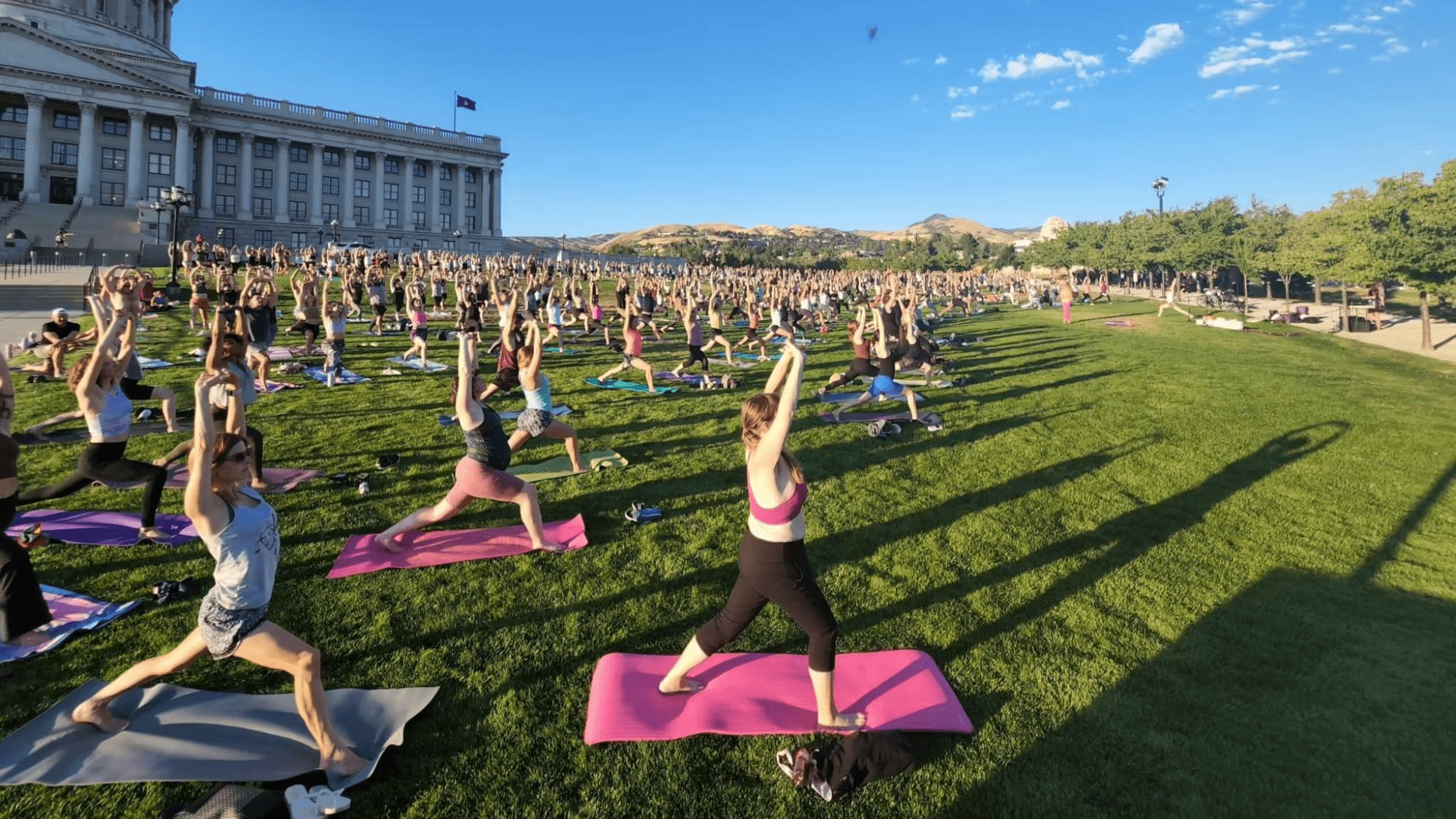 A large crowd doing yoga in front of the Utah capitol building